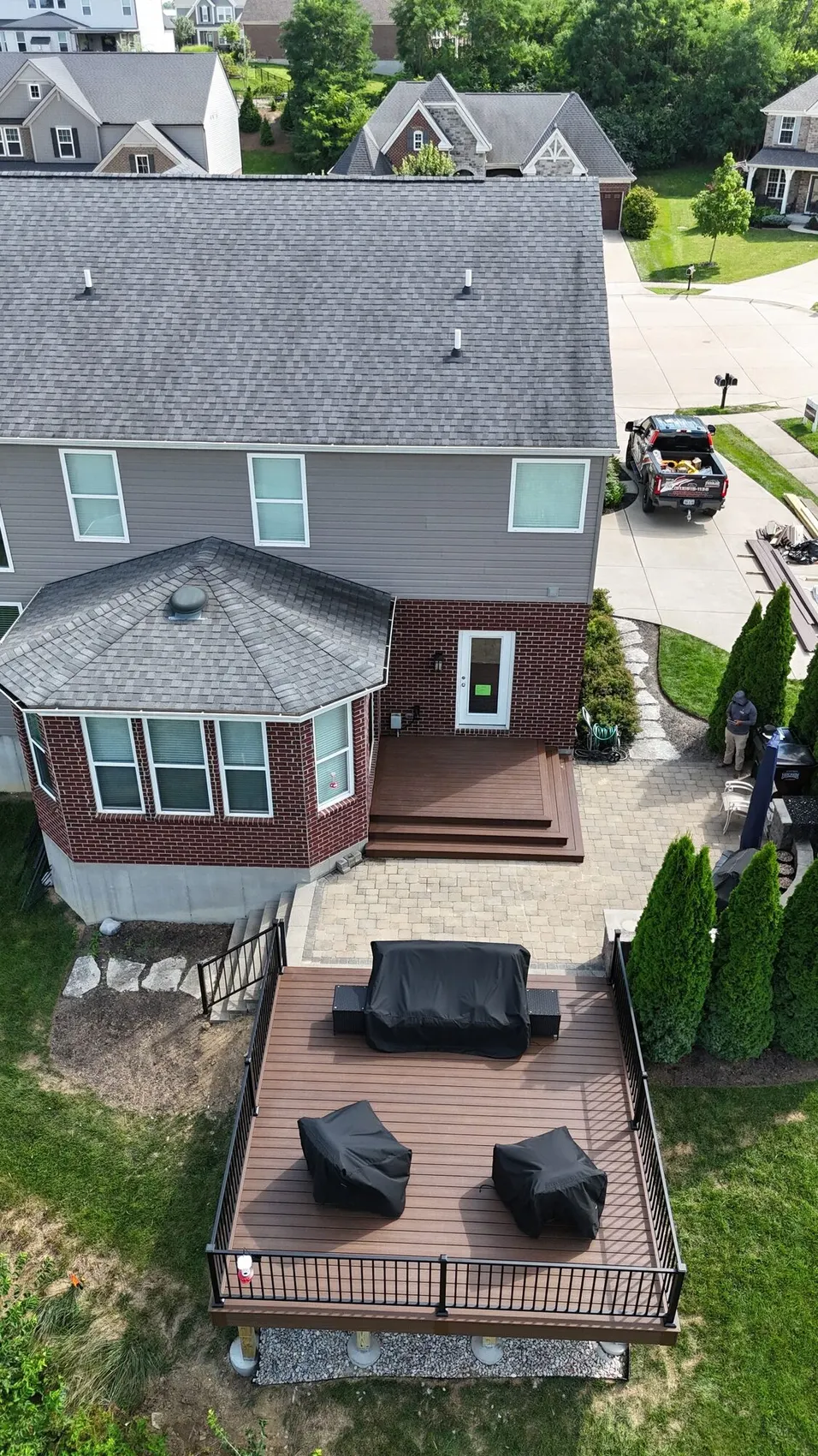 Aerial view of a composite deck and paver walkway at a brick home