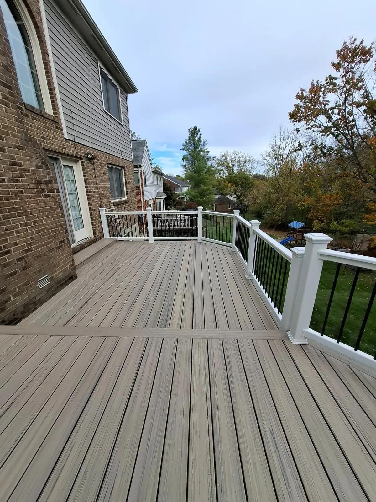 Grey brown composite deck with white posts and black balusters