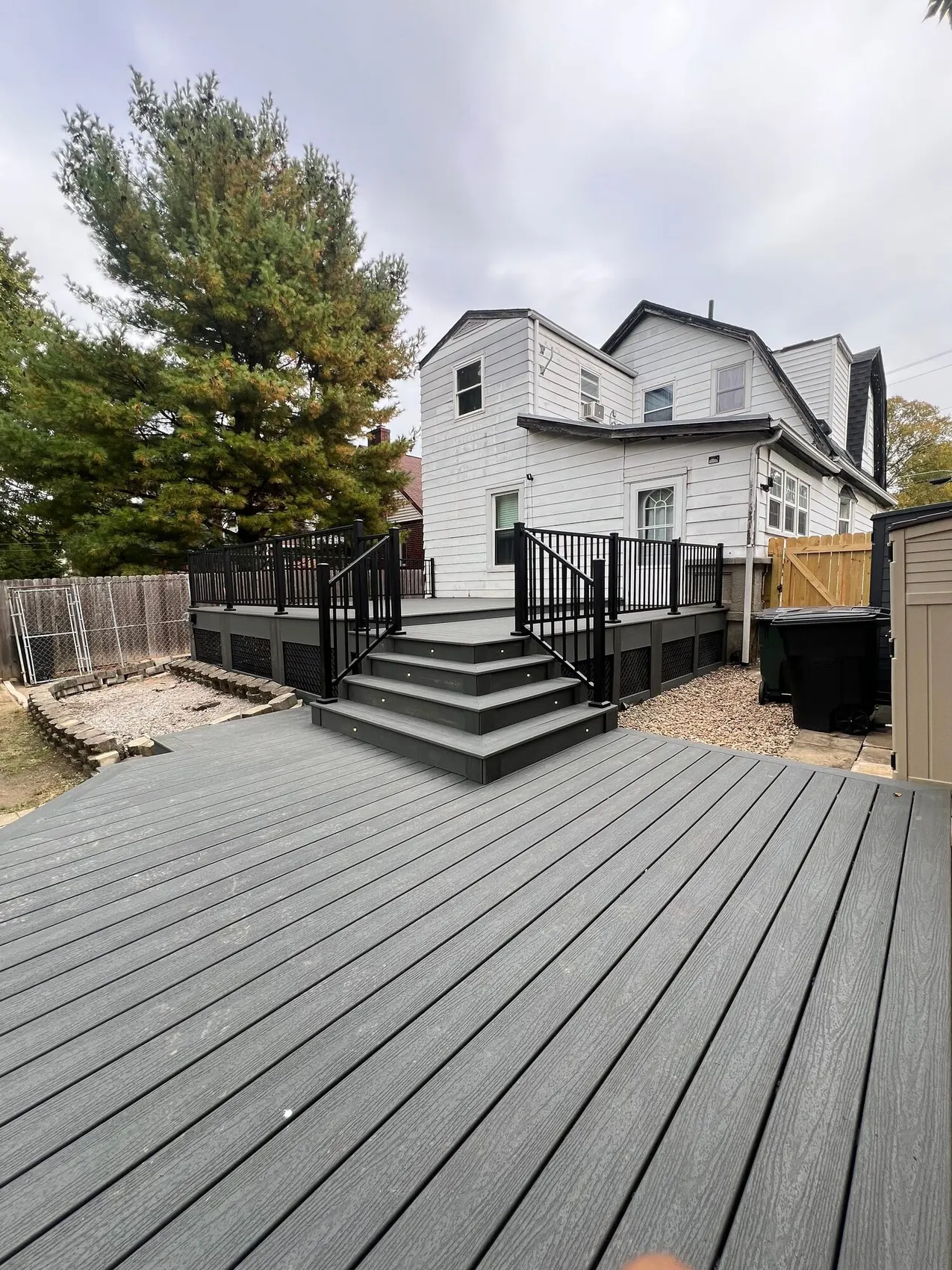 Grey composite deck with dark stairs leading down to the yard