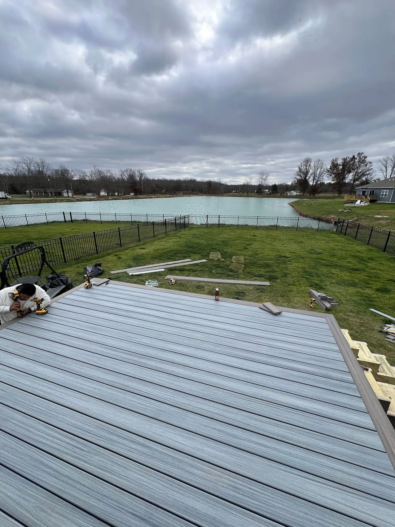 Prime Home Improvements crew fastening composite deck boards down onto a new frame