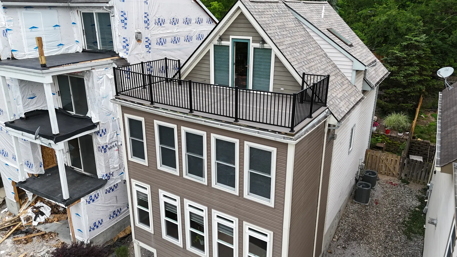 Rooftop deck with black aluminum railing on a three storey home, seen from above