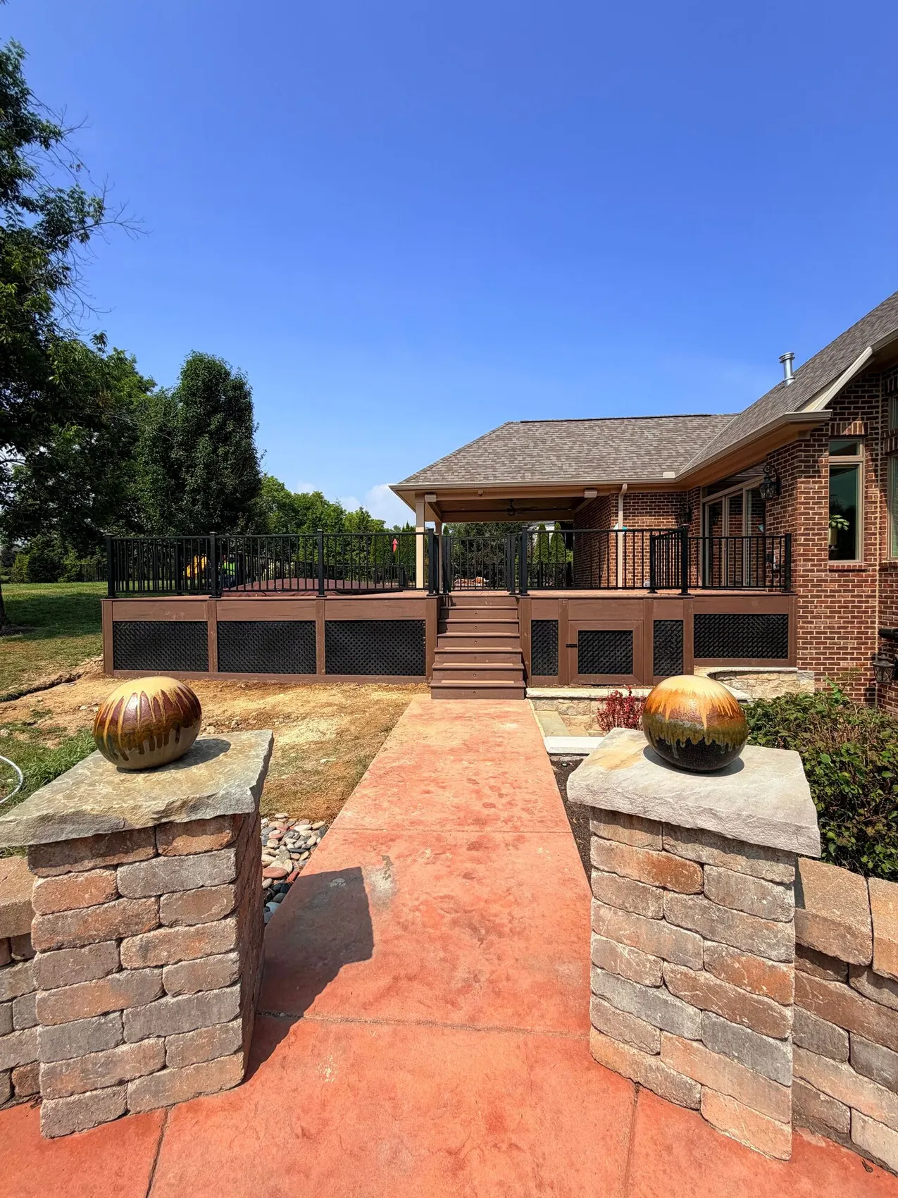 Stamped concrete patio with stone pillars at the entrance