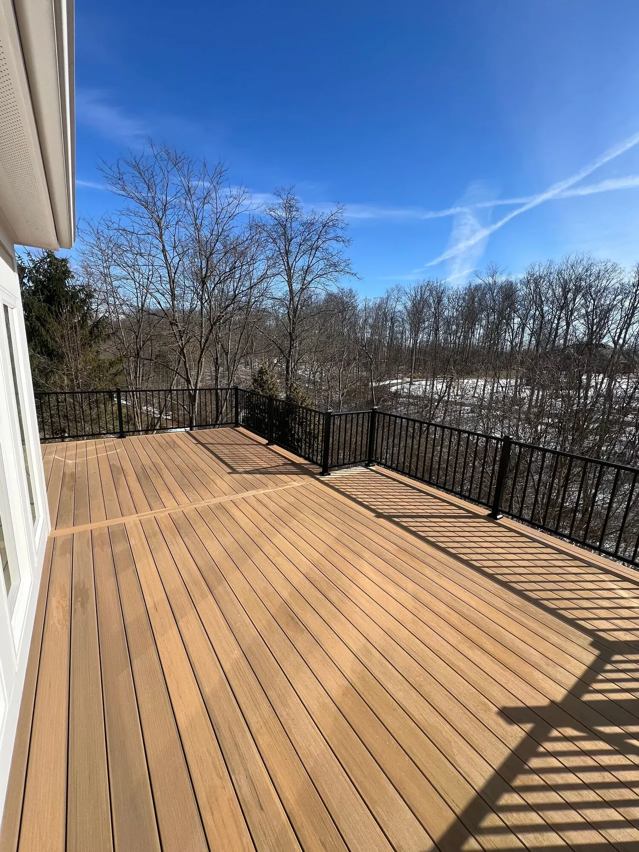 Sunlit composite deck with black aluminum railing
